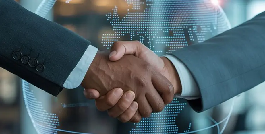 Business professionals handshake over glowing global map for IT partnership